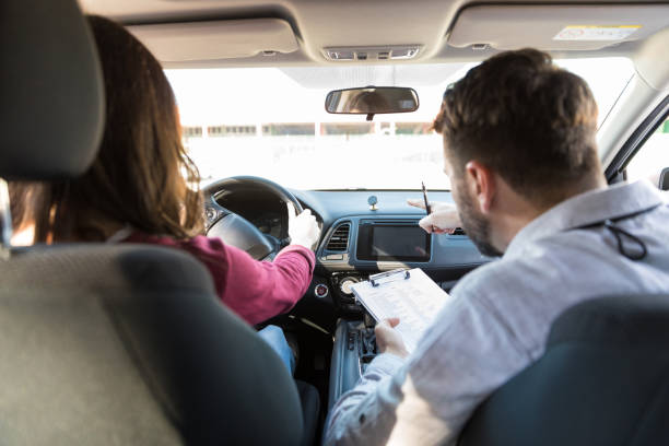 rear view of mid adult teacher pointing while woman parking car